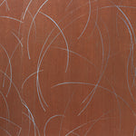 Detail of a wallpaper in an elongated paint splatter pattern in metallic silver on a rust field.