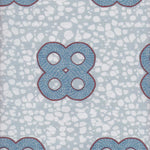 Detail of fabric in a curvilinear print in blue and red on a mottled blue field.