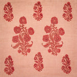 Detail of fabric in a floral grid print in red and maroon on a light orange field.