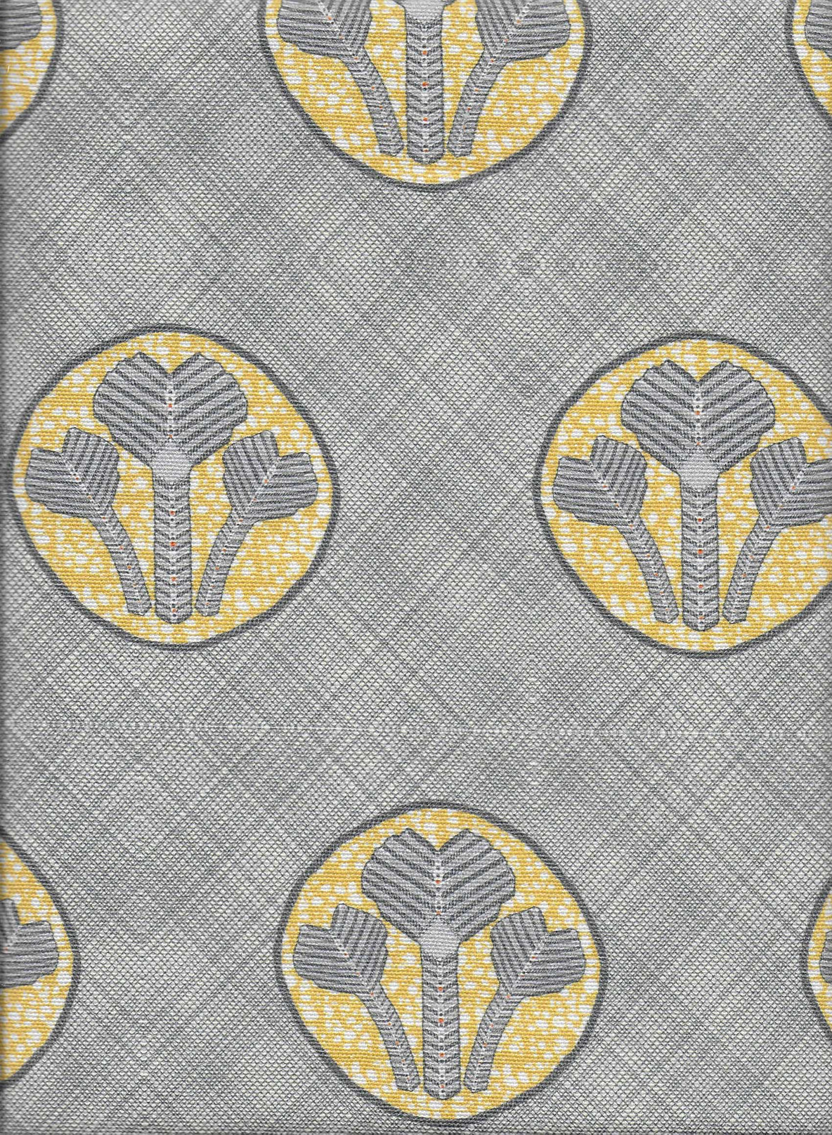 Detail of fabric in a repeating curvilinear floral print in yellow and gray on a gray field.