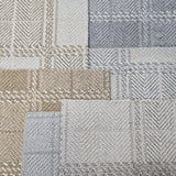 Broadloom carpet samples in a plaid pattern in a range of tan, cream, grey and blue. 