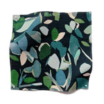 Square fabric swatch in a minimal leaf print in shades of blue and green on a navy field.