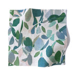 Square fabric swatch in a minimal leaf print in shades of blue, green and pink on a tan field.