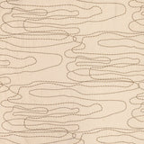 Detail of fabric in an abstract embroidered pattern in tan on a cream field.