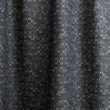 Draped fabric yardage in a textural geometric print in shades of gray on a charcoal field.