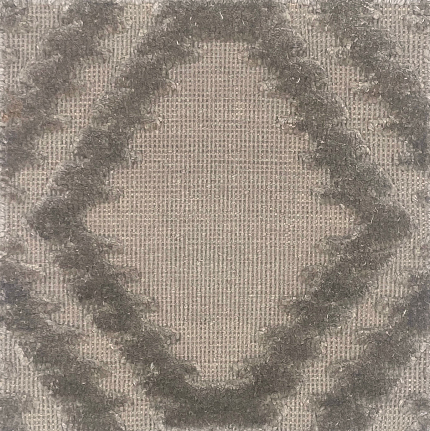 Handknotted rug with raised geometric pattern in grey. 