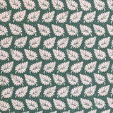 Detail of fabric in a repeating leaf print in white on a forest green field.