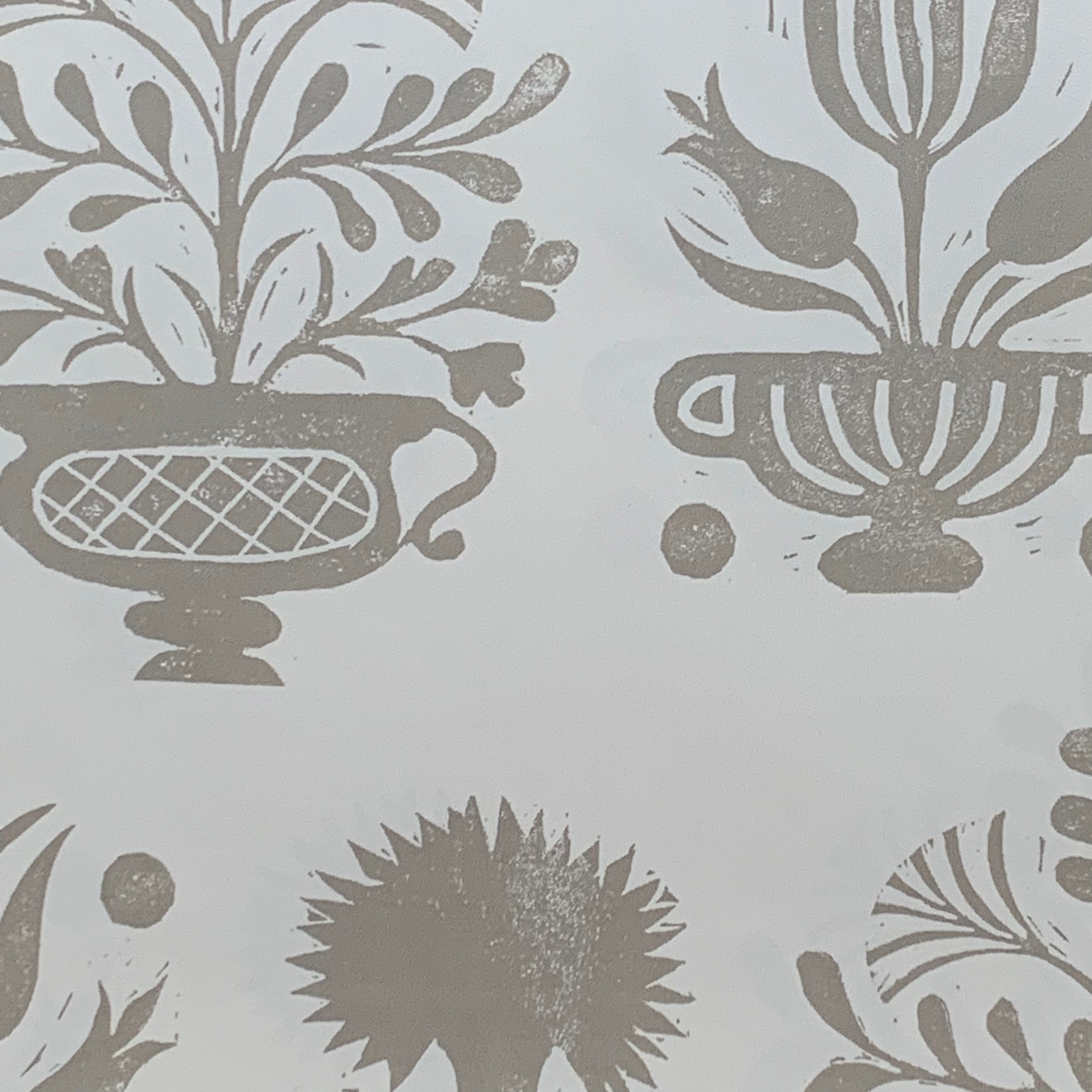 Close-up of wallpaper in a repeating vase and plant print in gray on a white field.