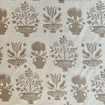 Detail of fabric in a repeating vase and plant print in tan on a white field.