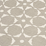 Fabric yardage in a floral lattice print in white on a greige field.