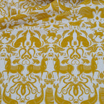 Draped patterned fabric with animals and sea creatures in yellow on a white background