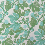 Patterned fabric with green and blue leaves and fruits on a light background