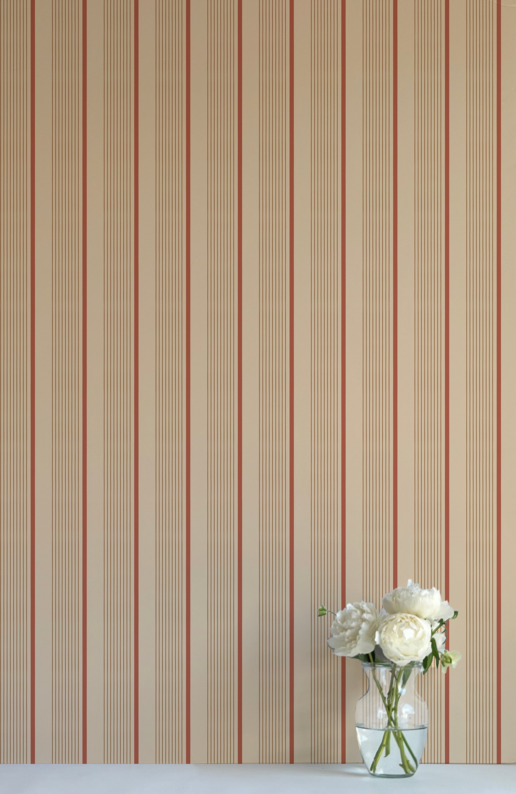 Striped wallpaper with a vase of flowers in the corner