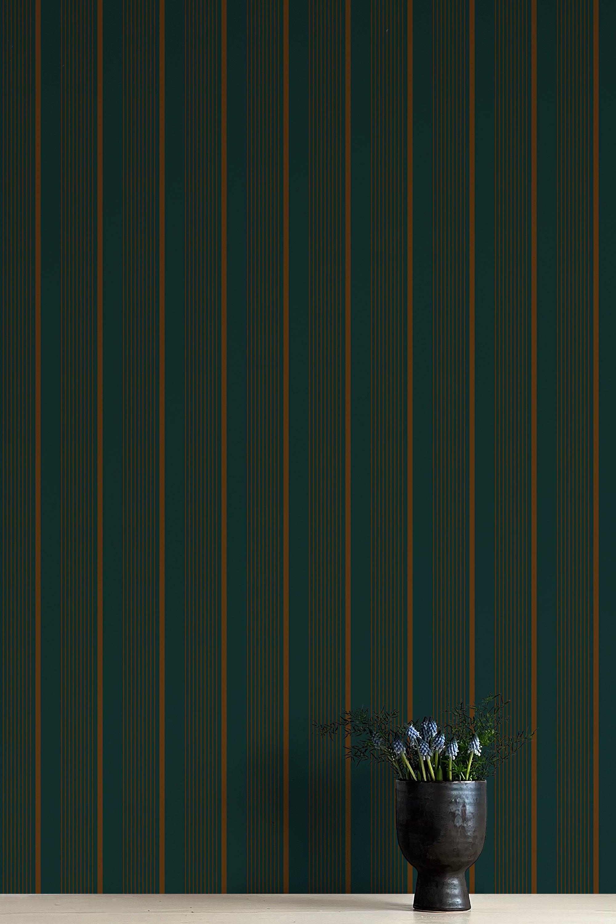 Vase with flowers against a dark green striped wall