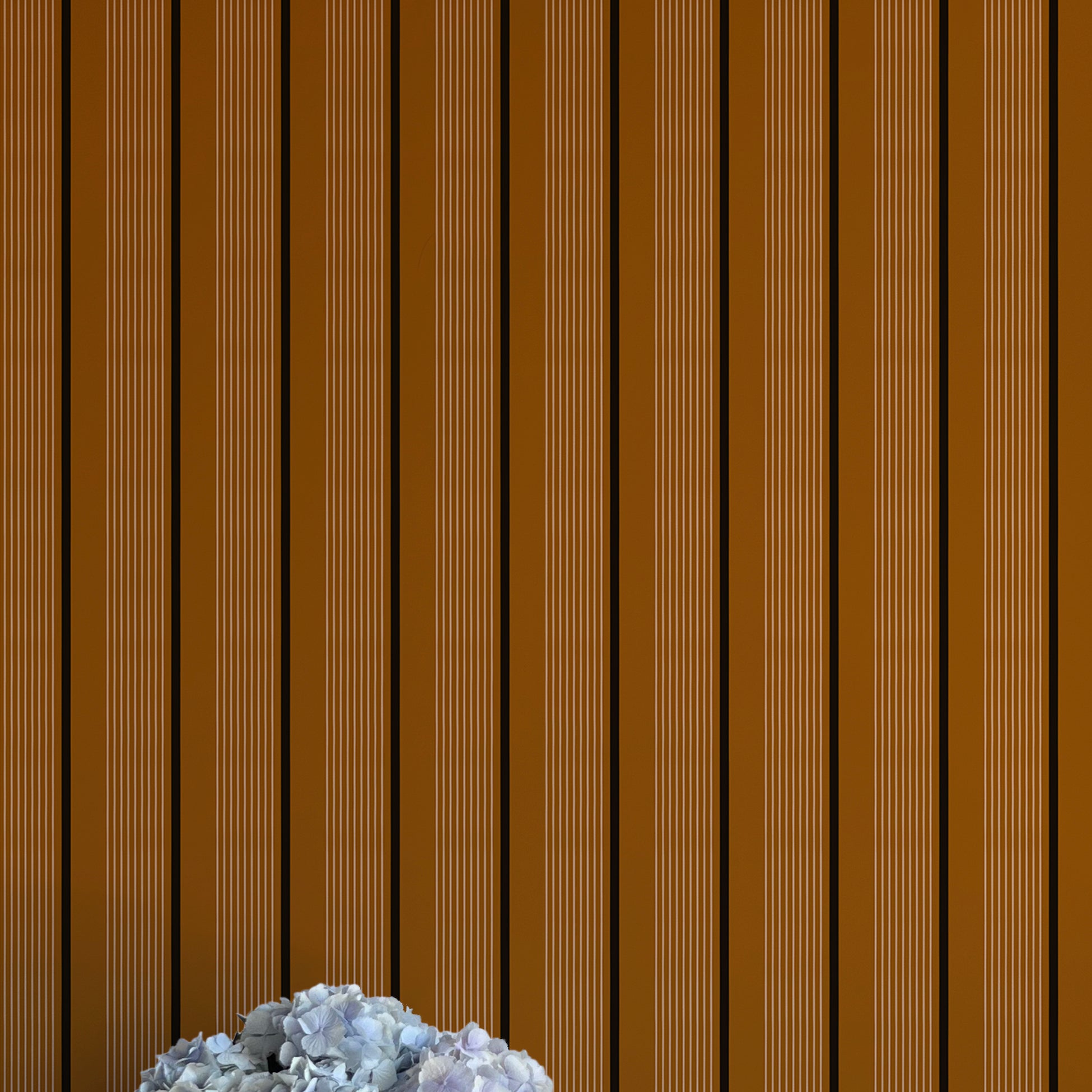 Striped brown wall with a vase of white flowers on a white surface