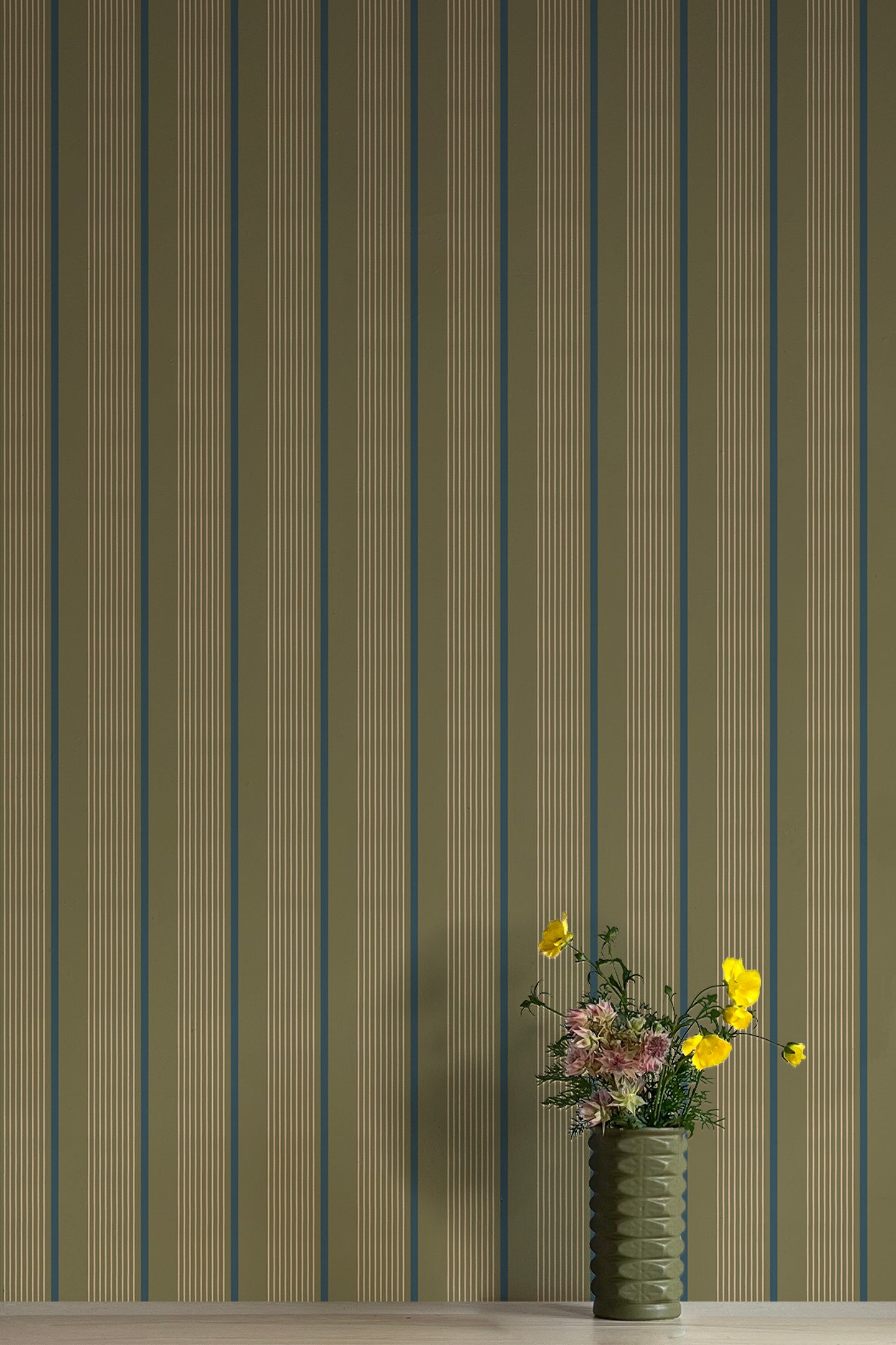 Vase of flowers against wallpaper with vertical stripes in green, blue and brown