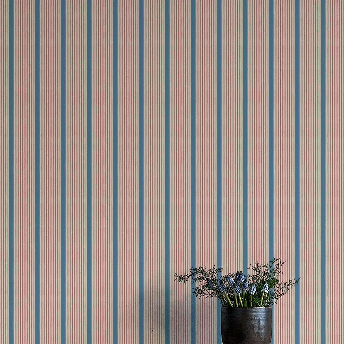 Wallpaper with vertical stripes in brown and blue on a plain background