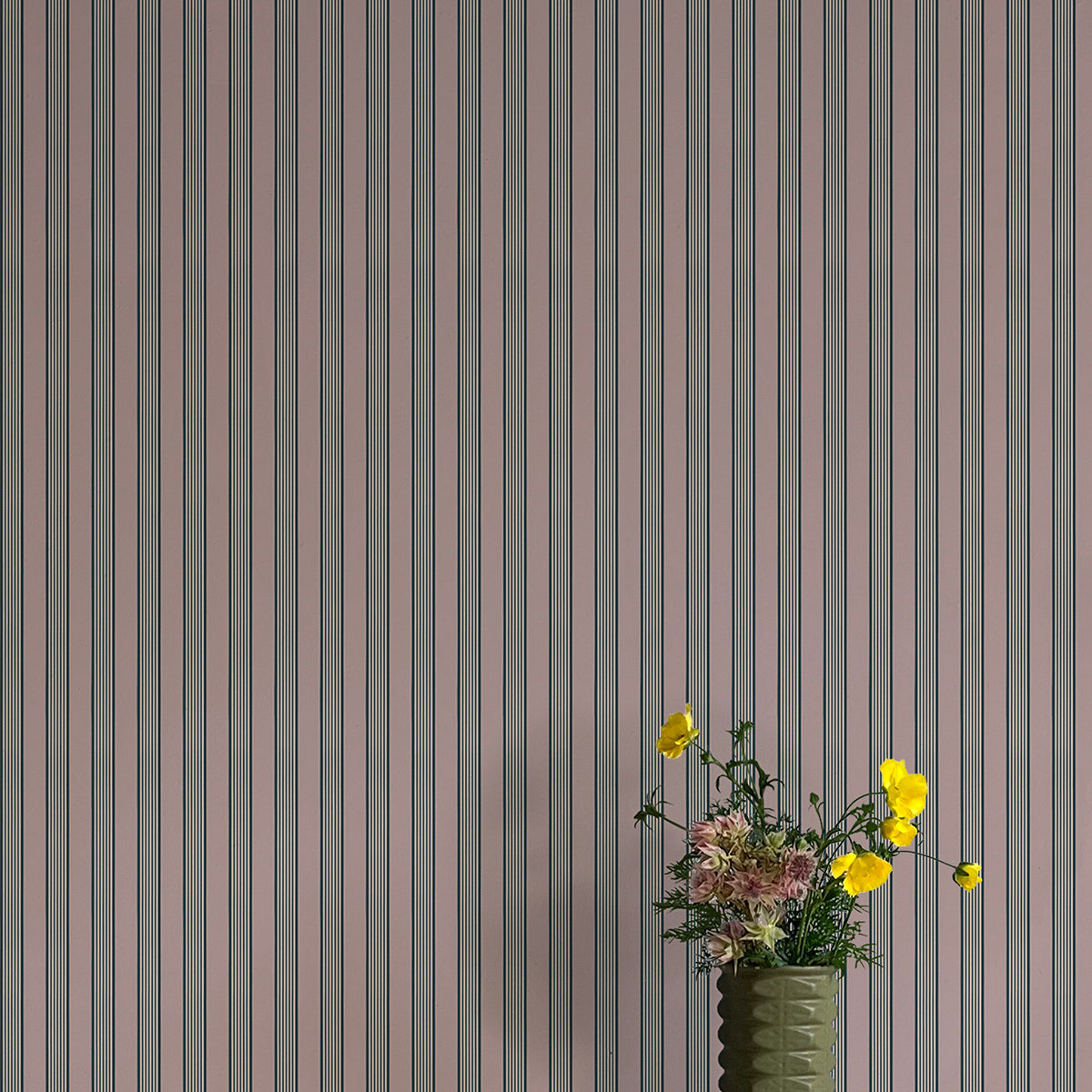 Vase with flowers against a striped wallpaper background