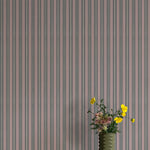 Vase with flowers against a striped wallpaper background