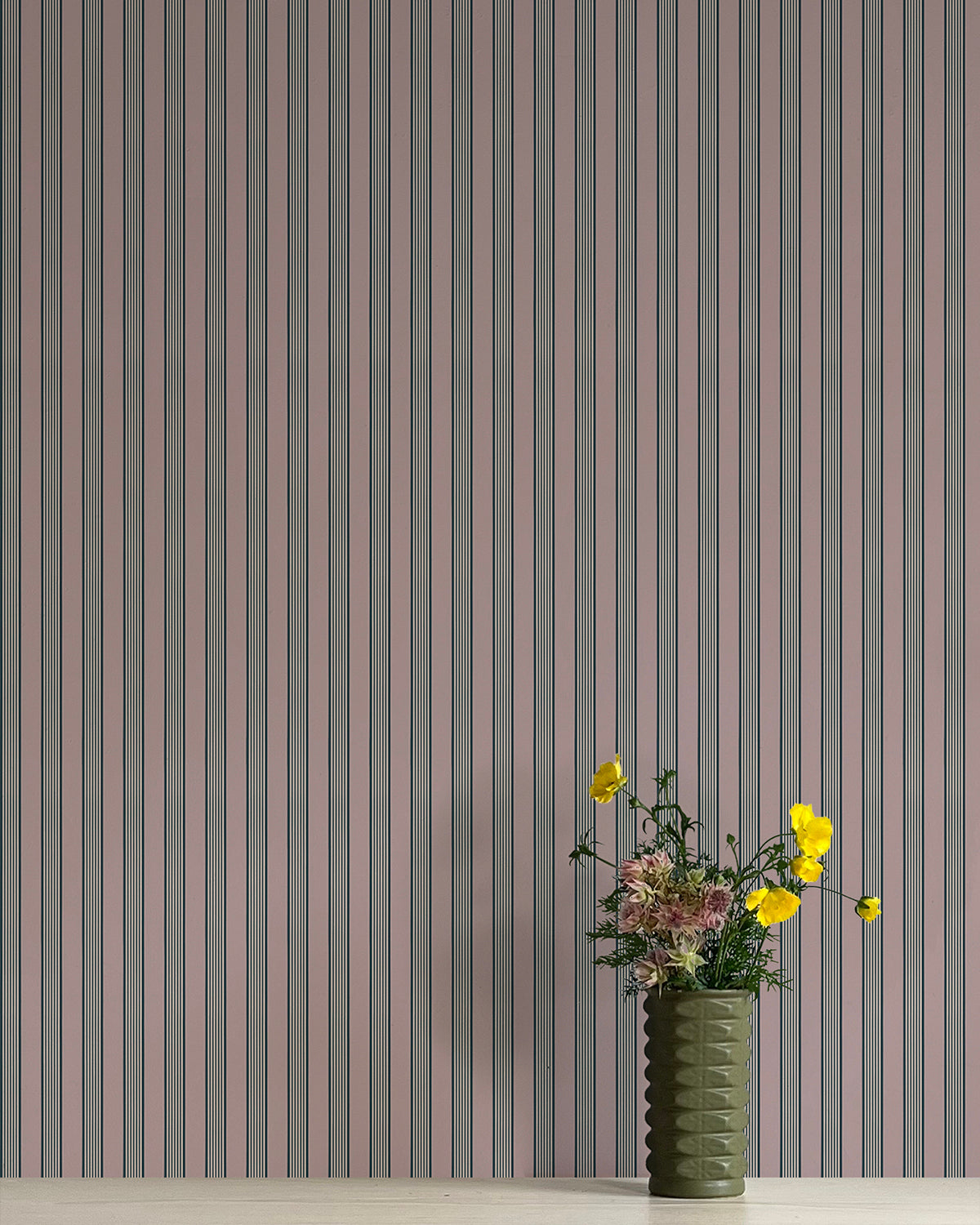 Vase with flowers against a striped wallpaper background