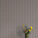 Vase with flowers against a striped wallpaper background