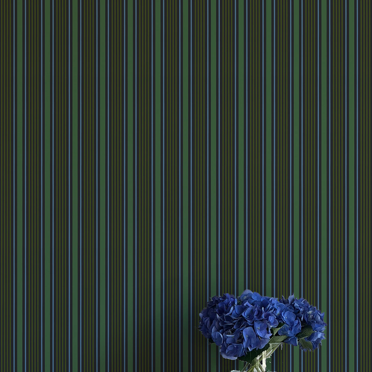 Striped wallpaper with a vase of blue flowers on a white surface
