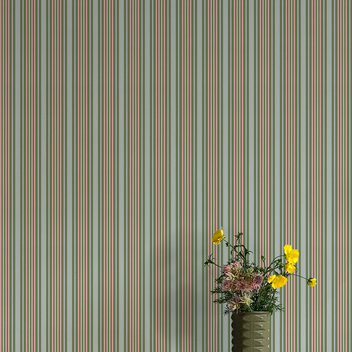 Striped wallpaper with a vase of flowers in the foreground