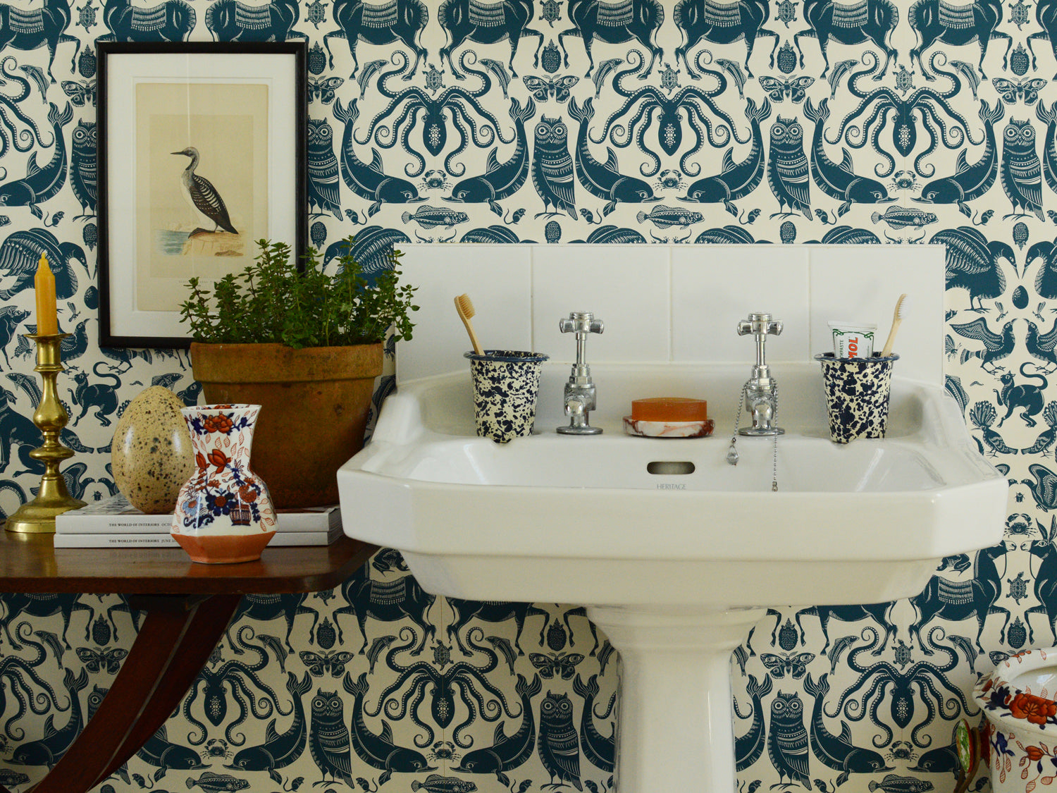 Bathroom with white sink against a patterned wallpaper wall