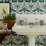 Bathroom with white sink against a patterned wallpaper wall