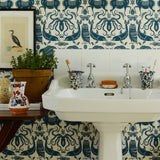 Bathroom with white sink against a patterned wallpaper wall