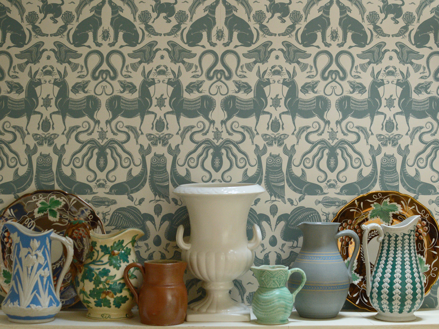 Collection of vintage ceramic items against a patterned wallpaper background