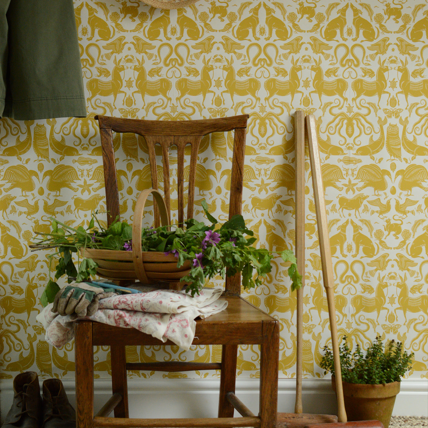 Wooden chair with a basket of flowers against a yellow patterned wall.