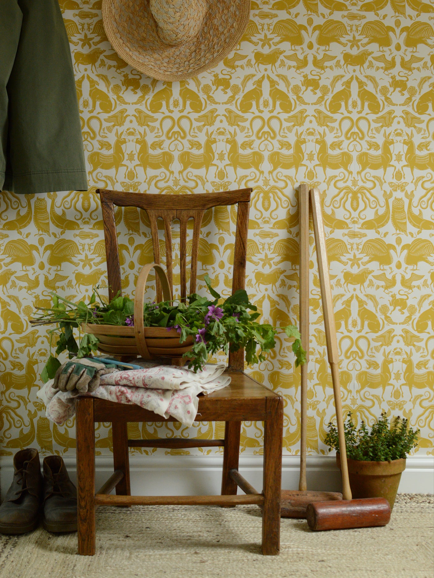 Wooden chair with a basket of flowers against a yellow patterned wall.
