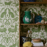 Shelves with decorative items against a green and white patterned wallpaper