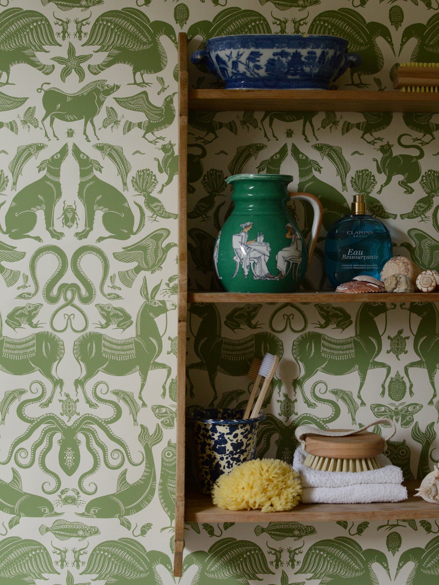 Shelves with decorative items against a green and white patterned wallpaper