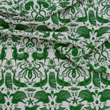 Draped patterned fabric with animals and sea creatures in green on a white background