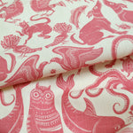 Draped patterned fabric with animals and sea creatures in pink on a white background