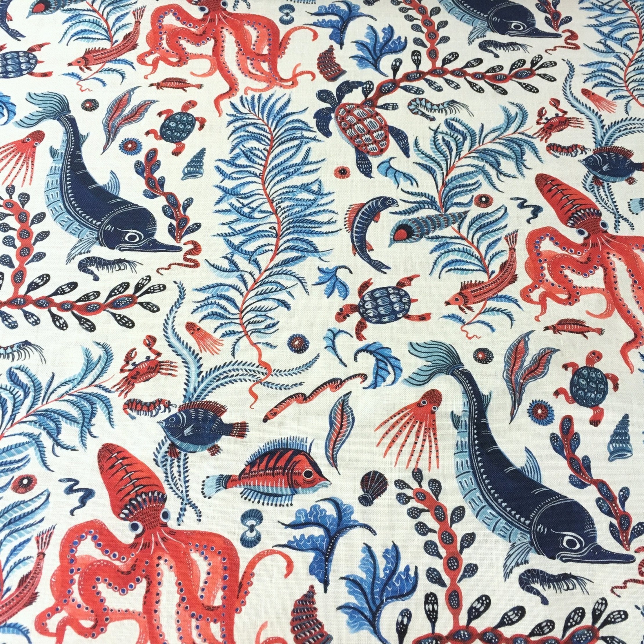 Ocean-themed fabric pattern with red, blue, and black sea creatures on a white background.