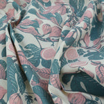 Floral fabric with pink flowers and green leaves on a white background