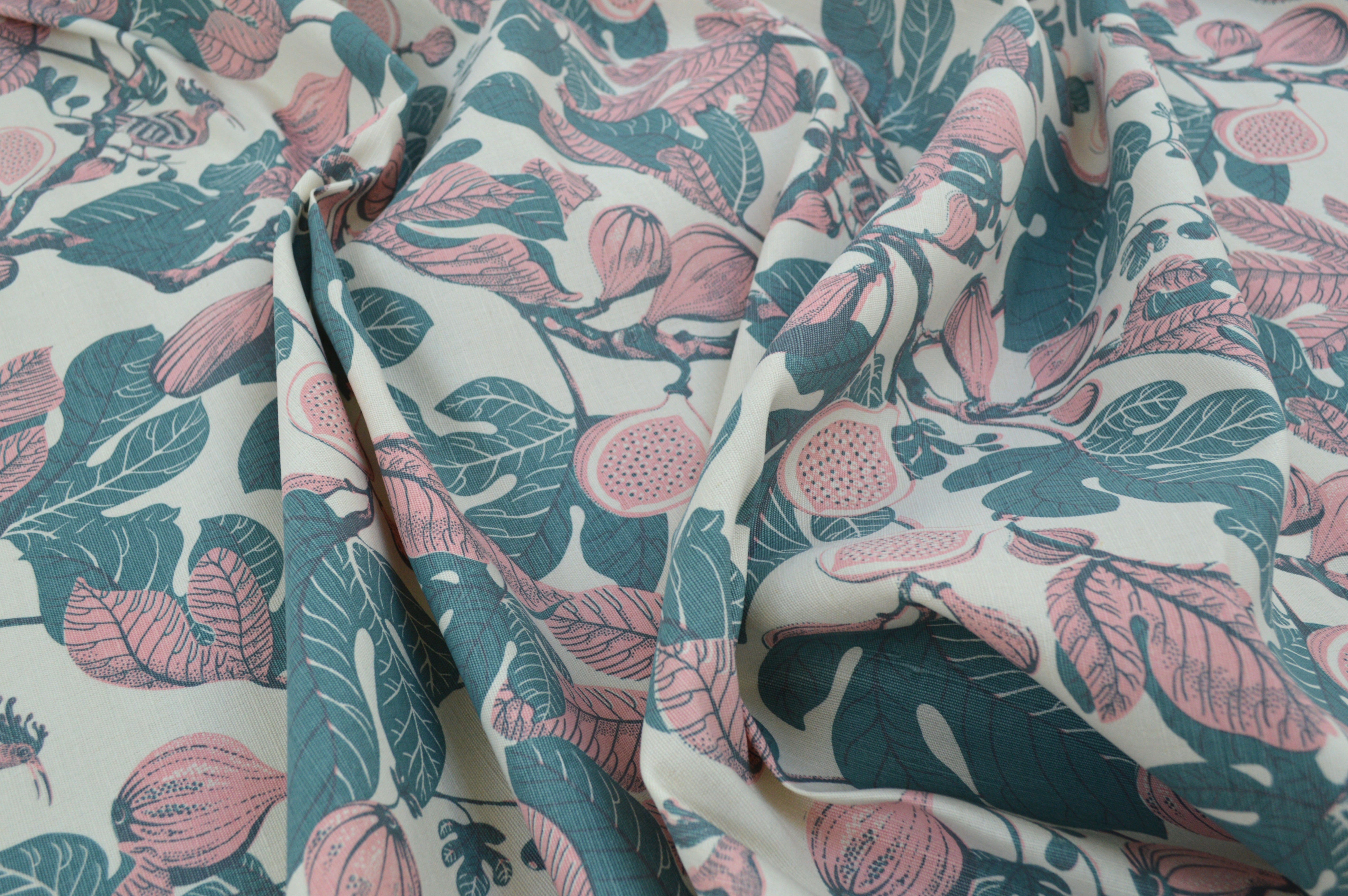 Floral fabric with pink flowers and green leaves on a white background