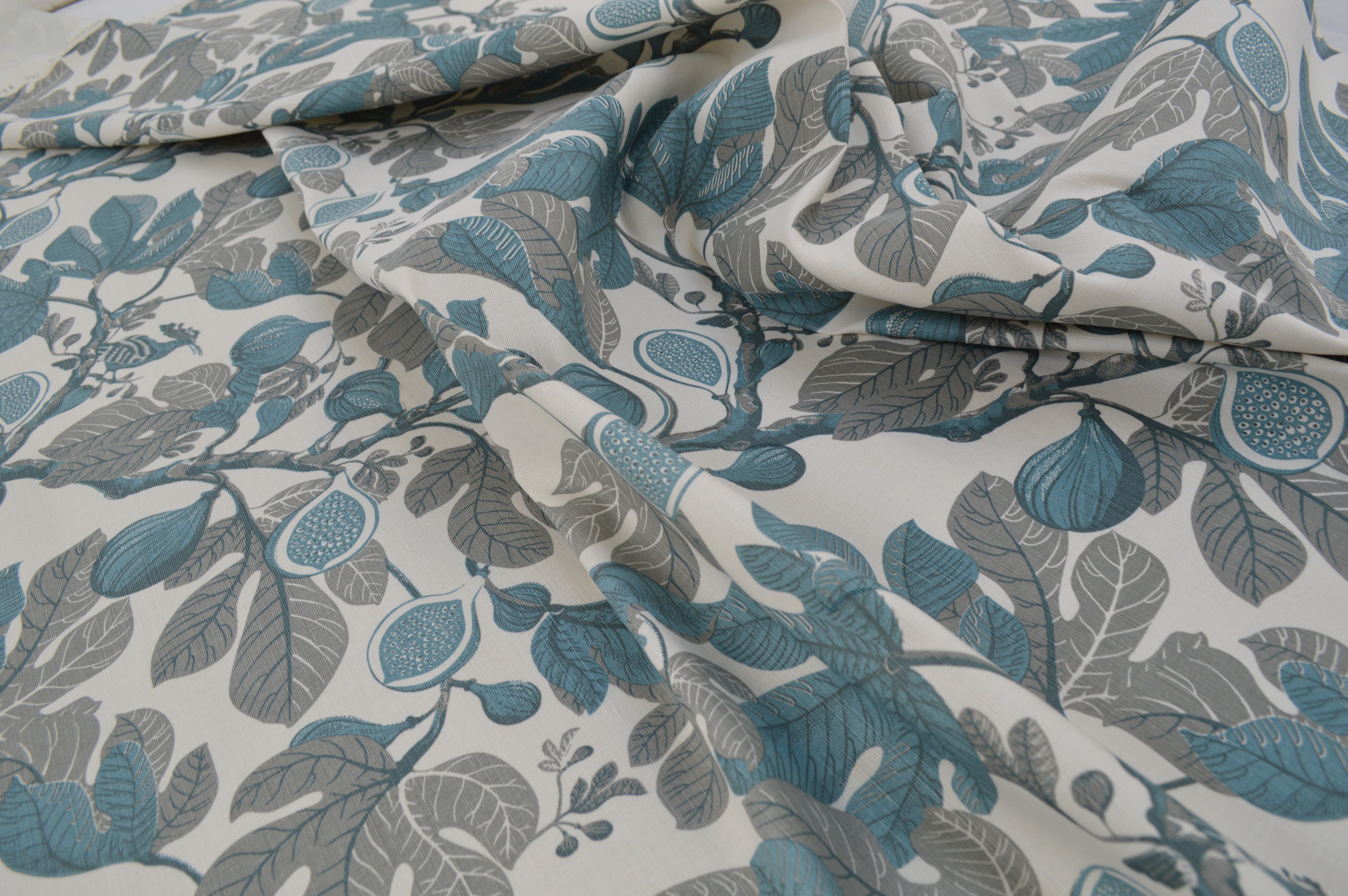 Floral patterned fabric with blue and gray leaves on a white background