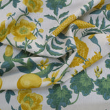 Floral fabric with yellow flowers and green leaves on a white background