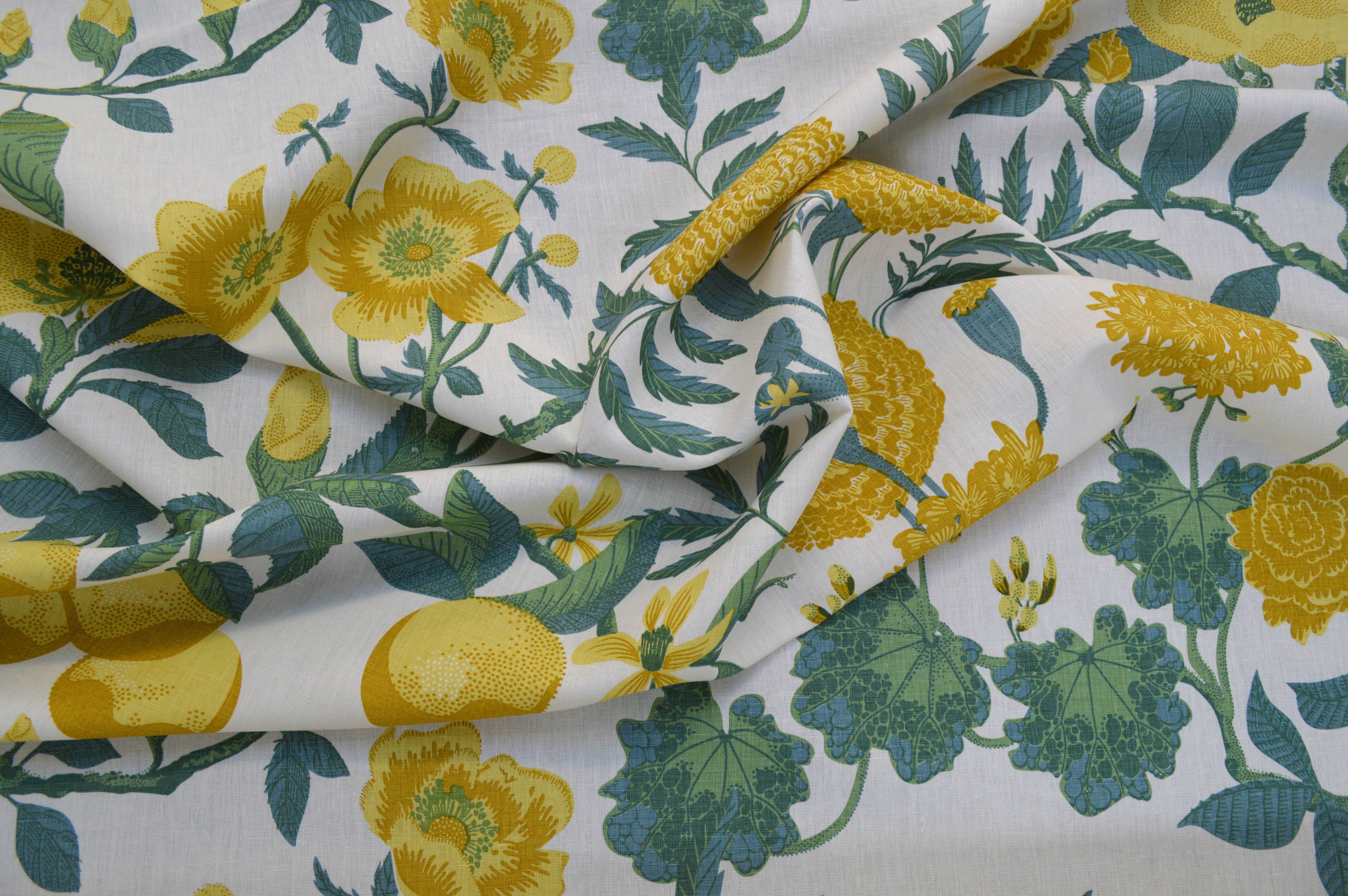 Floral fabric with yellow flowers and green leaves on a white background