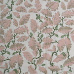Patterned fabric with pink leaves and green acorns on a light background
