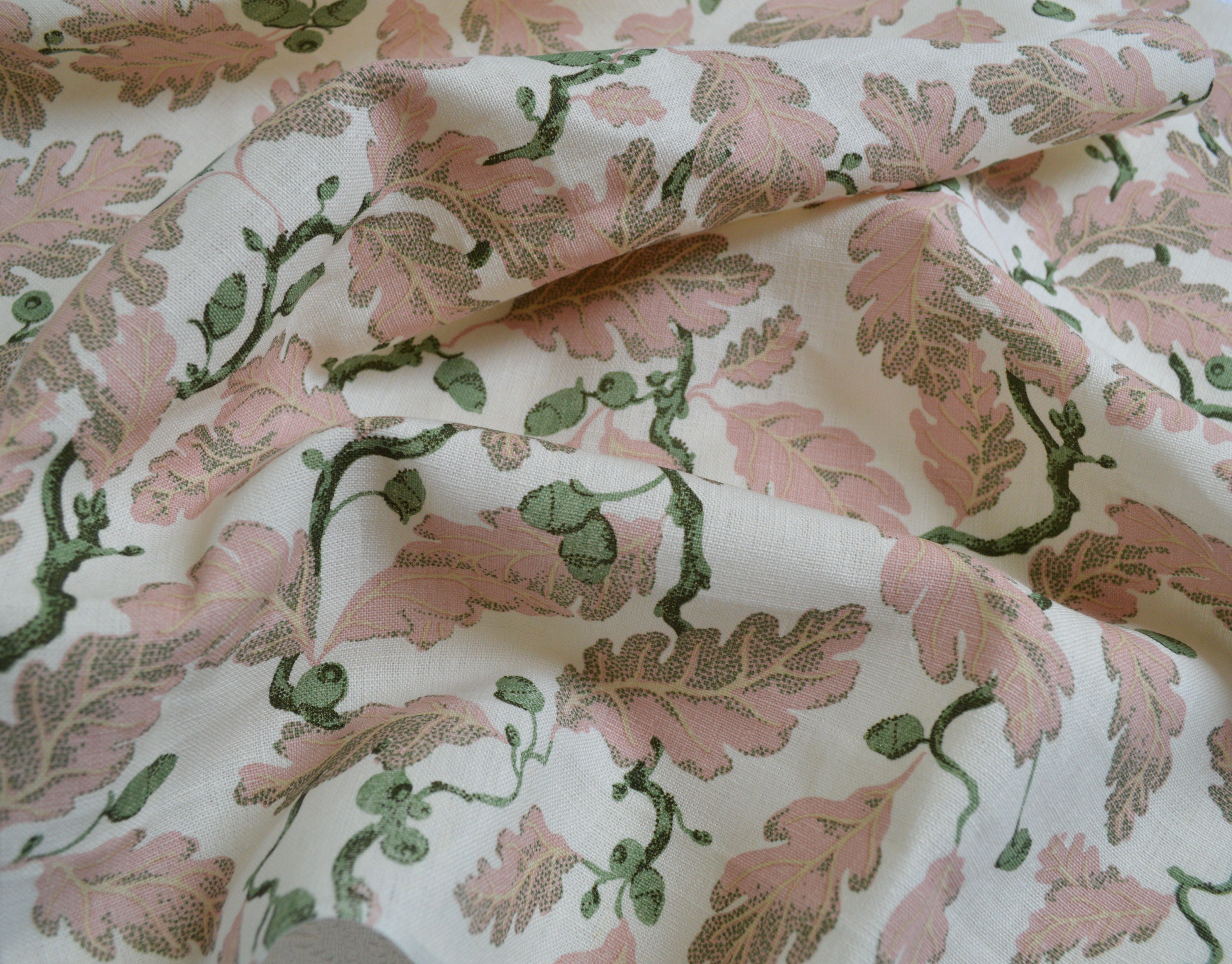 Botanical fabric with pink and green pattern on a white background