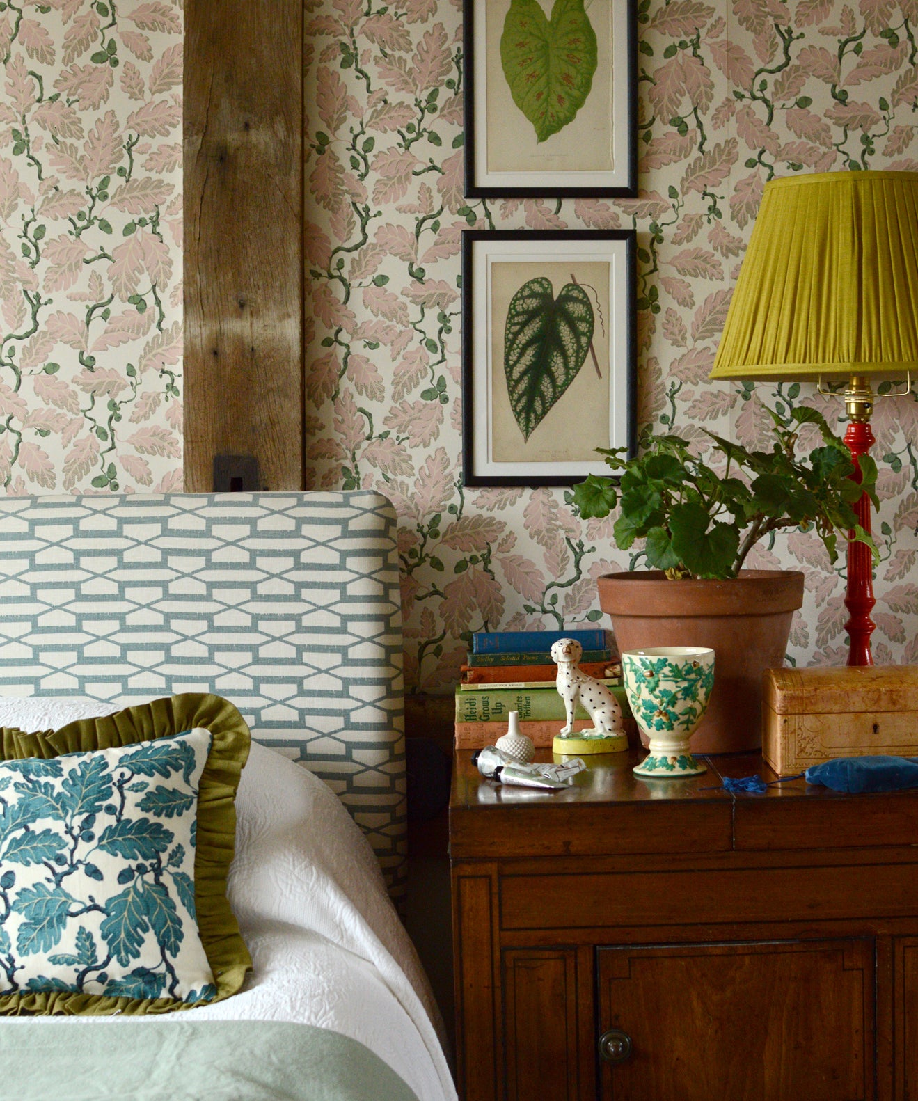 Decorative bedroom with floral wallpaper, a bed, and a wooden nightstand.