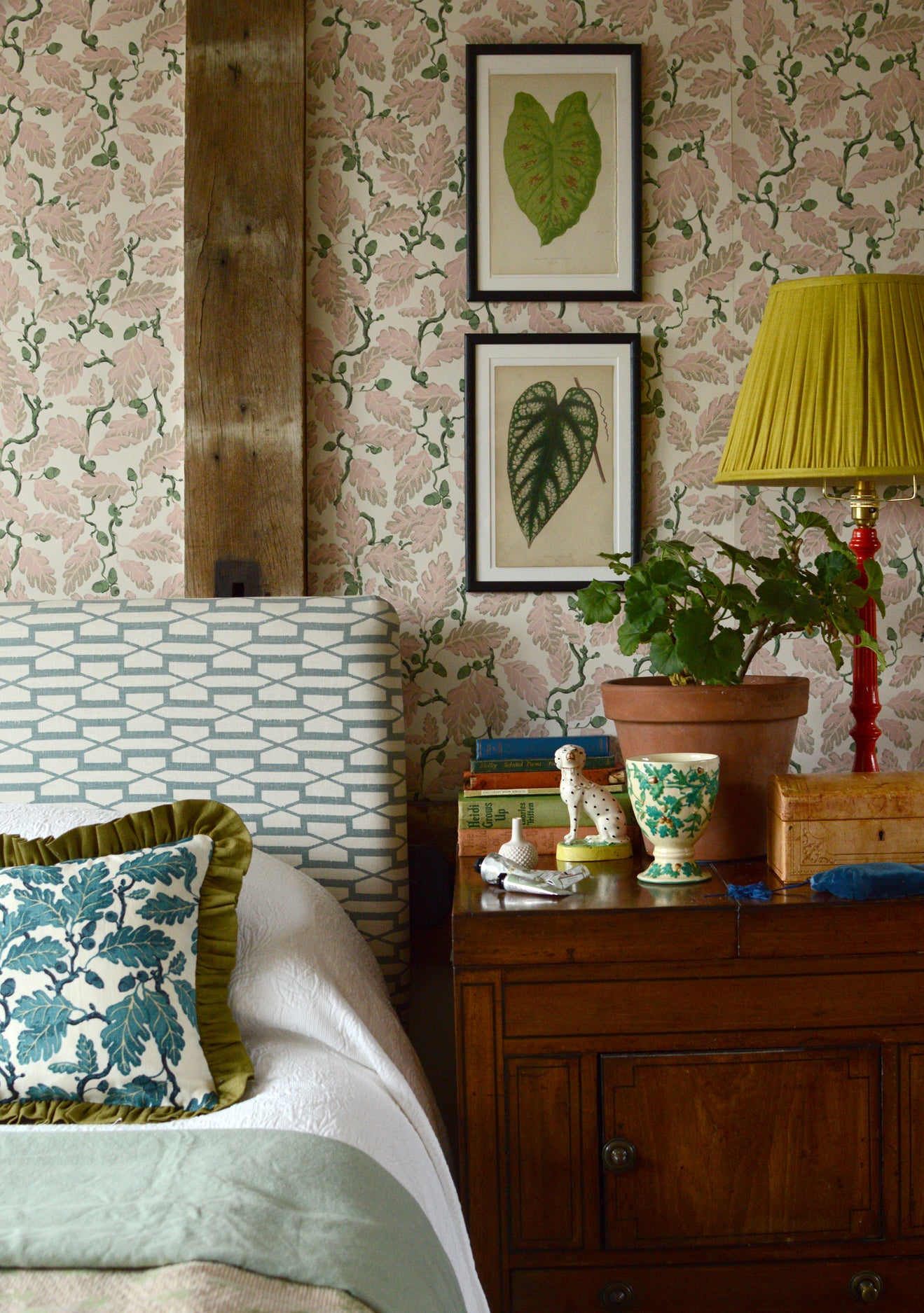 Decorative bedroom with floral wallpaper, a bed, and a wooden nightstand.