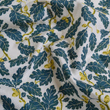 Fabric with blue leaf and yellow acorn pattern on a white background