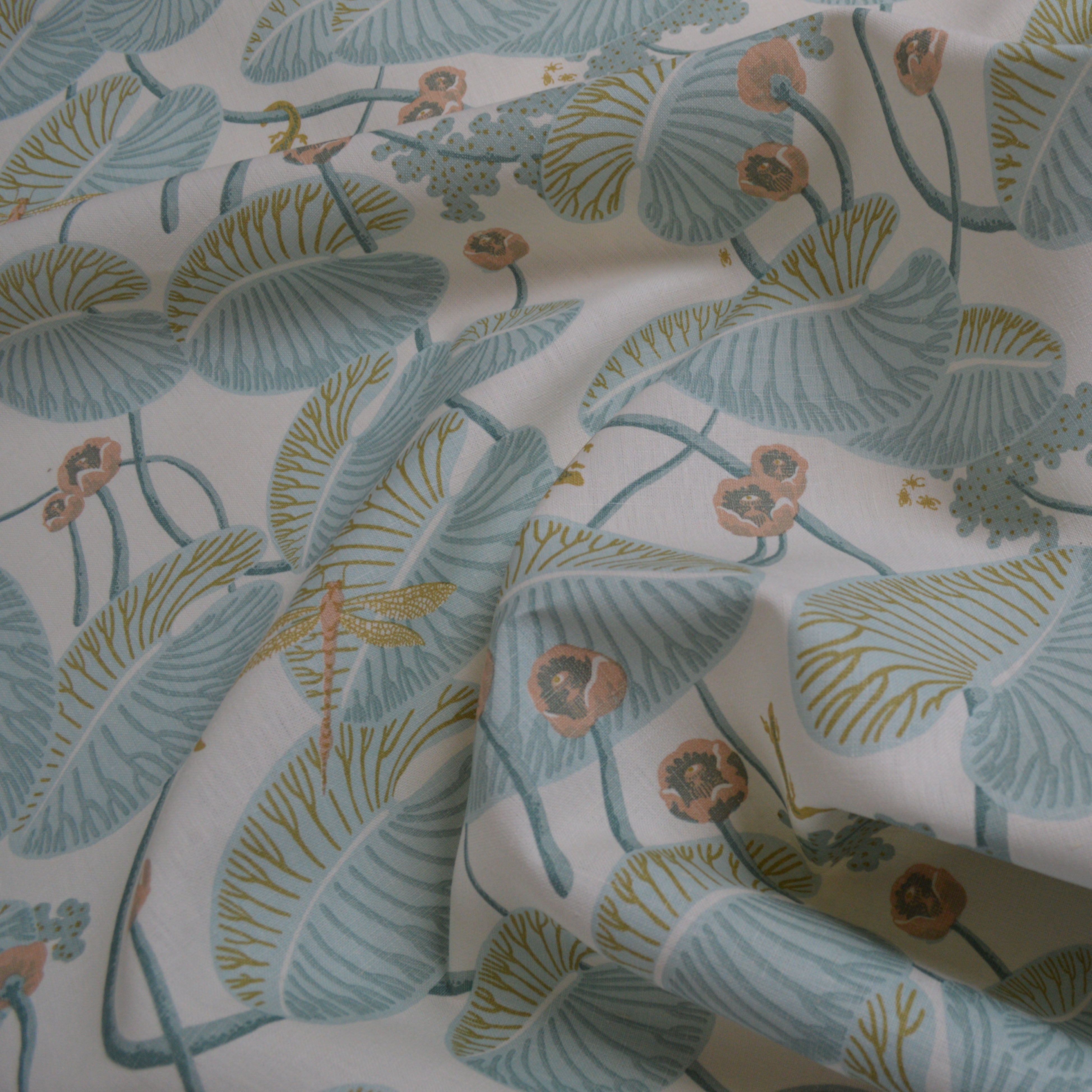 Floral fabric with green leaves and pink flowers on a white background