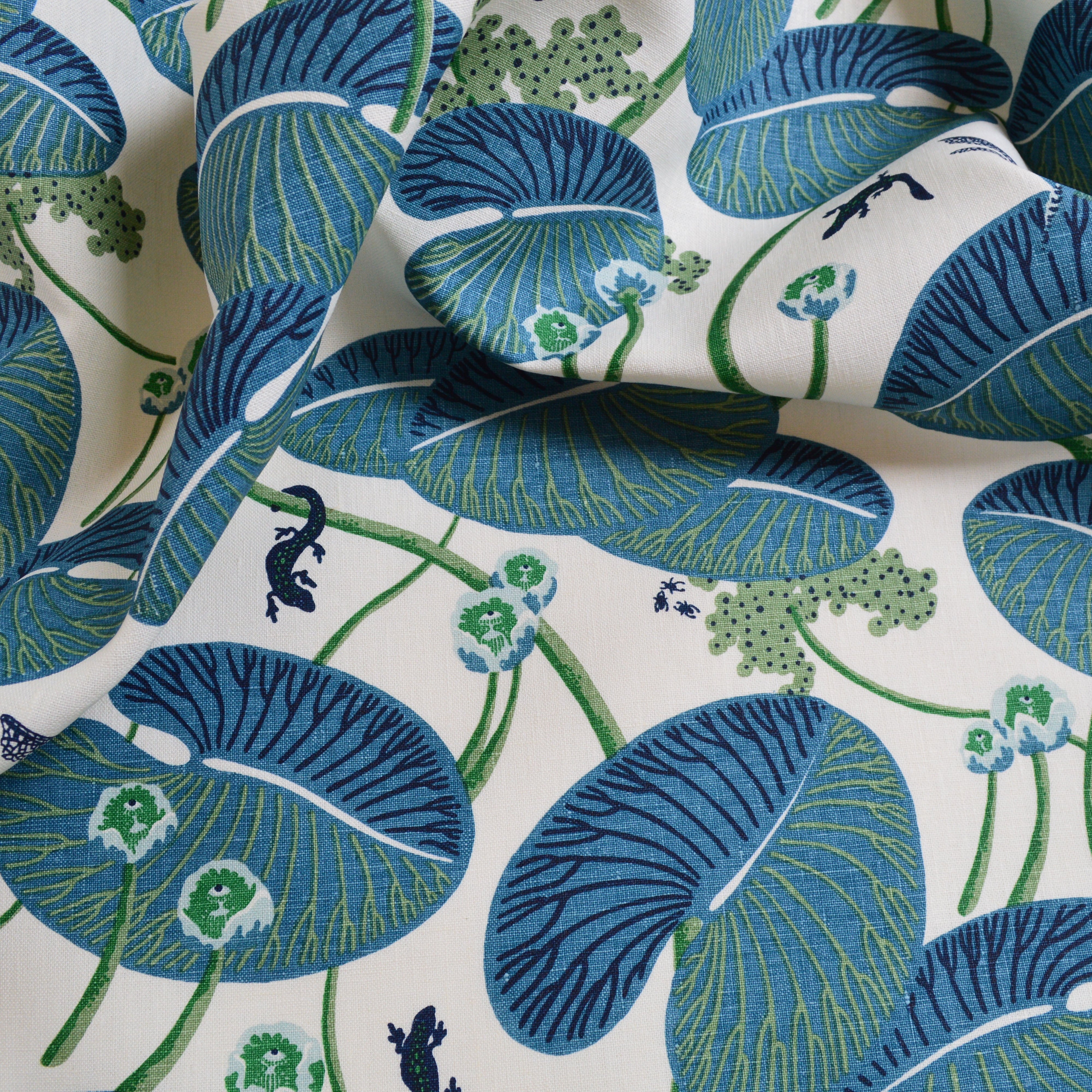 Fabric with blue and green lily pad pattern on a white background
